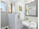 Powder room with a pedestal sink, decorative mirror, and natural light from window at 476 Sapphire Dr, Carmel, IN 46032
