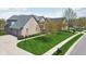 This brick house has an attached garage and is surrounded by a lush manicured lawn at 476 Sapphire Dr, Carmel, IN 46032