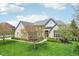 A bright brick house has an arched entry, manicured lawn, and blooming trees at 476 Sapphire Dr, Carmel, IN 46032
