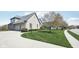 Side view of a gray brick home featuring an attached two-car garage and green lawn at 476 Sapphire Dr, Carmel, IN 46032