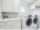 Convenient laundry room with built-in cabinets, counterspace and modern washer and dryer at 476 Sapphire Dr, Carmel, IN 46032