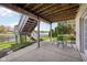 Covered patio features outdoor seating and staircase to backyard with serene lake views at 476 Sapphire Dr, Carmel, IN 46032