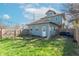 A spacious backyard featuring a wooden fence, fire pit, and lush green grass at 504 S Lebanon St, Lebanon, IN 46052
