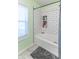 A bathroom featuring a white tub with updated tile surround, niche storage, and modern flooring at 504 S Lebanon St, Lebanon, IN 46052