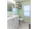 A clean bathroom with modern fixtures, bright green walls, a large mirror, and gray flooring at 504 S Lebanon St, Lebanon, IN 46052