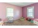 A charming bedroom featuring pink and purple walls, two windows, and playing space at 504 S Lebanon St, Lebanon, IN 46052