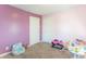 A brightly painted bedroom featuring two doors, plush carpet, and various toys at 504 S Lebanon St, Lebanon, IN 46052