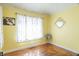 Sunlit bedroom featuring hardwood floors, a window, and yellow walls at 504 S Lebanon St, Lebanon, IN 46052