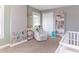 Cozy Bedroom with a white crib, comfortable armchair, bookshelf and cute wall decals at 504 S Lebanon St, Lebanon, IN 46052