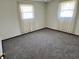 This cozy bedroom features two bright windows and neutral carpeting at 508 E Hillside Dr, Anderson, IN 46011