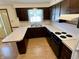 Functional kitchen featuring white countertops, dark cabinets, and essential appliances at 508 E Hillside Dr, Anderson, IN 46011