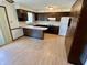 Cozy kitchen with dark cabinetry, white countertops, and breakfast bar area at 508 E Hillside Dr, Anderson, IN 46011