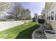 Backyard view with lush green grass, a white picket fence, and mature trees on a sunny day at 537 Weyworth Pl, Greenwood, IN 46142