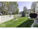 Green backyard with a white picket fence, lush landscaping, and mature trees at 537 Weyworth Pl, Greenwood, IN 46142