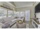 Bright sunroom featuring a plush white sectional sofa and ample natural light from the windows at 537 Weyworth Pl, Greenwood, IN 46142