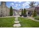 Backyard features a stone patio, walkway, outdoor fireplace, and meticulously landscaped lawn at 5455 S 800 E, Zionsville, IN 46077
