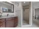 Bathroom with double sink vanity, granite counters, decorative mirror, and a walk-in shower at 5455 S 800 E, Zionsville, IN 46077