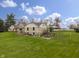 Inviting exterior featuring stone, siding, manicured lawn, patios, and landscaped flower beds at 5455 S 800 E, Zionsville, IN 46077
