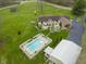 Aerial view of backyard with in-ground pool, hot tub, patio with seating, and lush landscaping at 5455 S 800 E, Zionsville, IN 46077