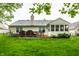 A well-maintained backyard with a wooden deck, green grass, and mature trees offers outdoor living space at 558 Prince Dr, Greenwood, IN 46142