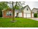 Lovely home with brick and siding, green lawn, and mature tree offers a welcoming curb appeal at 558 Prince Dr, Greenwood, IN 46142