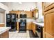 Efficient kitchen with wood cabinets, black appliances, and neutral countertops at 558 Prince Dr, Greenwood, IN 46142