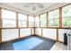 Bright sun room with multiple windows offering verdant outdoor views and unique blue and black flooring at 558 Prince Dr, Greenwood, IN 46142
