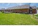 Brick home featuring a well-kept lawn, a wooden deck, and a brick patio with air conditioning unit at 575 Crestpoint Ln, Plainfield, IN 46168