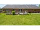 Expansive backyard features a well-maintained lawn, mature trees and a wooden deck at the rear of the brick house at 575 Crestpoint Ln, Plainfield, IN 46168