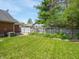 Backyard featuring a green lawn, wooden fence, and diverse landscaping, providing a private outdoor space at 575 Crestpoint Ln, Plainfield, IN 46168