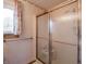 Bathroom featuring a shower with glass doors, a window, and floral wallpaper at 575 Crestpoint Ln, Plainfield, IN 46168