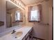 Bathroom with a window, bright vanity lights, sink, and mirror at 575 Crestpoint Ln, Plainfield, IN 46168