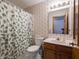 Cozy bathroom featuring a shower with patterned curtain, wallpaper, and a wood vanity sink at 575 Crestpoint Ln, Plainfield, IN 46168