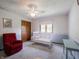 Bright bedroom featuring a ceiling fan, crib, and comfortable reading chair at 575 Crestpoint Ln, Plainfield, IN 46168