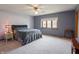 Spacious bedroom featuring plush carpet, neutral paint, a ceiling fan, and a large window providing natural light at 575 Crestpoint Ln, Plainfield, IN 46168