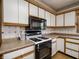 Close up of kitchen featuring stove, oven, and microwave with bright white cabinetry at 575 Crestpoint Ln, Plainfield, IN 46168