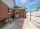 A quaint backyard concrete patio featuring a brick wall and white wooden fence, offers a private outdoor space at 575 Crestpoint Ln, Plainfield, IN 46168