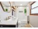 Bathroom features a large mirror, sink, toilet, and subway tiled shower with skylight at 5831 Bar Del W Dr, Indianapolis, IN 46221