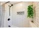 Close up of the shower featuring white subway tile and a hanging plant at 5831 Bar Del W Dr, Indianapolis, IN 46221