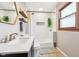 Bathroom features a large mirror, sink, toilet, and subway tiled shower with skylight at 5831 Bar Del W Dr, Indianapolis, IN 46221