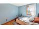 Serene bedroom featuring a cozy bed, hardwood floors, and a sunlit window at 5831 Bar Del W Dr, Indianapolis, IN 46221