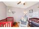 A peaceful Bedroom with a red crib, changing table, comfortable chair and soft wall color at 5831 Bar Del W Dr, Indianapolis, IN 46221