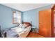 Bright bedroom with blue walls, hardwood floors, and a window letting in natural light at 5831 Bar Del W Dr, Indianapolis, IN 46221