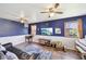 Cozy living room features a hardwood floor, piano, ceiling fans and a mounted television at 5831 Bar Del W Dr, Indianapolis, IN 46221