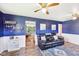 Comfortable living room with a blue accent wall, ceiling fans, and a large leather sofa at 5831 Bar Del W Dr, Indianapolis, IN 46221