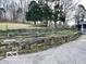 Stone retaining wall creates terraced levels on property, with mature trees and lush greenery at 5846 Bellsville Pike, Columbus, IN 47201