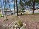 Secluded backyard featuring mature trees, stone fire pit, and distant house views at 5846 Bellsville Pike, Columbus, IN 47201