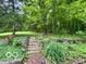 Spacious backyard with lush greenery, mature trees, and charming terraced landscaping at 5846 Bellsville Pike, Columbus, IN 47201