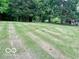 Expansive backyard featuring a lush lawn, mature trees, and a charming home in the background at 5846 Bellsville Pike, Columbus, IN 47201