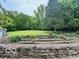 Expansive backyard featuring lush greenery, mature trees, and attractive stone terracing at 5846 Bellsville Pike, Columbus, IN 47201